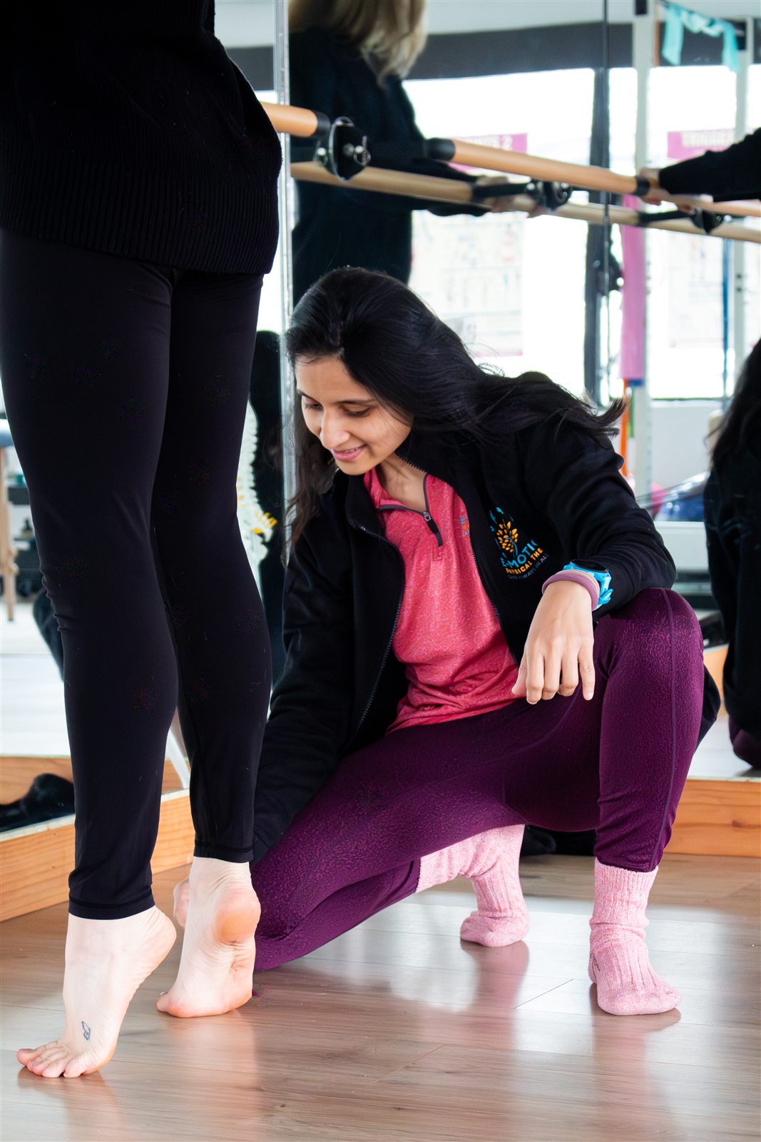 Dr. Foram Patel demonstrating an injury-prevention stretch with a dancer